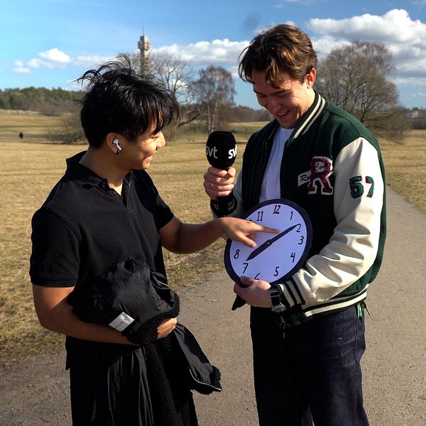 Reporter håller i en klocka.