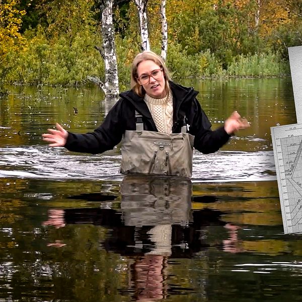 SVT:s reporter vadar i vatten vid översvämmad väg.