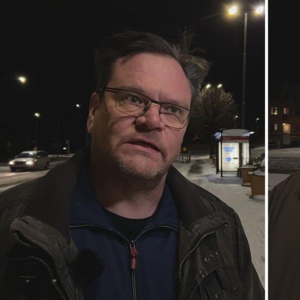 Mörk bild från en nattlig stadsmiljö som visar två män stående på en trottoar. Till vänster en man klädd i en mörk jacka, till höger en man som bär en hatt och en ljusare jacka. Båda männen ser åt olika håll mot omgivningen, med gatubelysning och en busshållplats i bakgrunden.