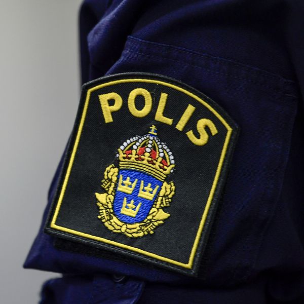 Polislogga och en kvinna som tittar in i kameran