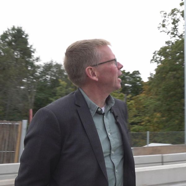 Utredaren på Transportstyrelsen tittar upp på de nya broavgiftskamerorna på nya Skurubron.