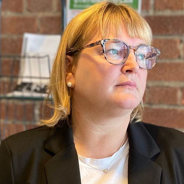 Till vänster åklagaren Christina Edlund Nilsson, till höger syns en polis och en tekniker som står vid en bil och pratar.