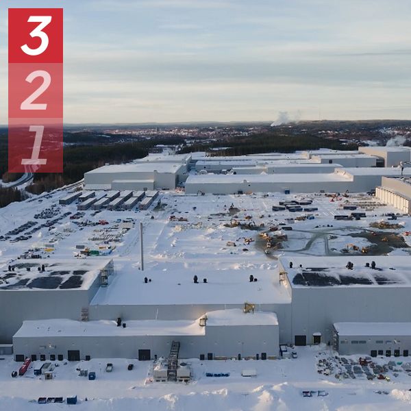 En delad bild som visar två scener. Den vänstra sidan visar en vinterlandskap med snötäckta byggnader och parkerade transportfordon vid en stor industrianläggning, med en klar himmel i bakgrunden. Den högra sidan visar en person som står framför en studio med flera skärmar i bakgrunden, vilket indikerar en nyhetsmiljö.