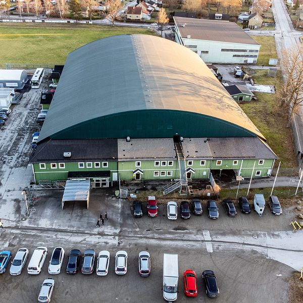 Tvådelad bild. Vänster: Grön industribyggnad med parkeringsplats. Höger: En man i kostym.
