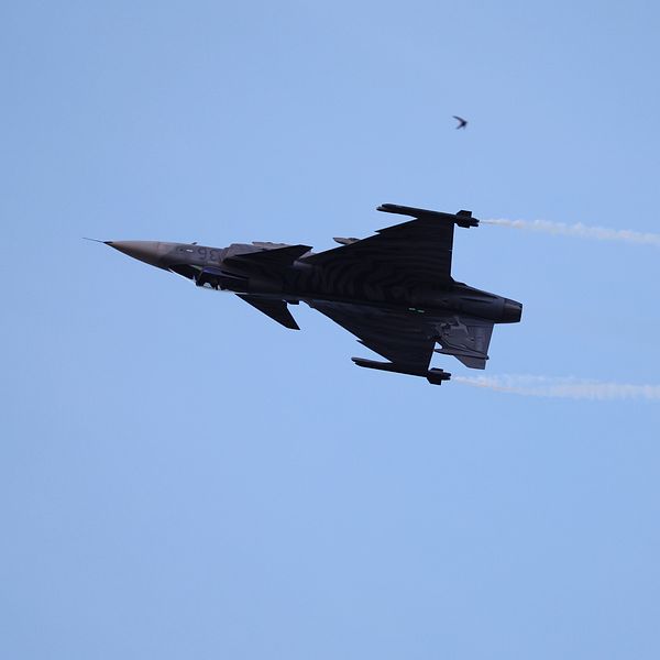 Svenskt Gripen-plan under flygning på blå himmel