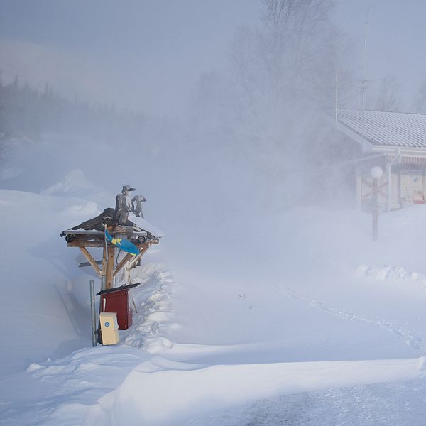 En röd stuga i Stekenjokk där det drevar mycket snö.