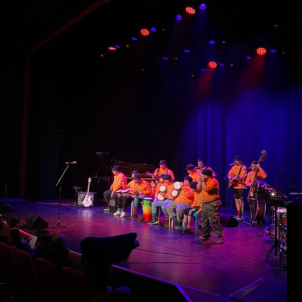 Tvådelad bild. Till vänster: orkester spelar på scen. Till höger: två personer poserar tillsammans.