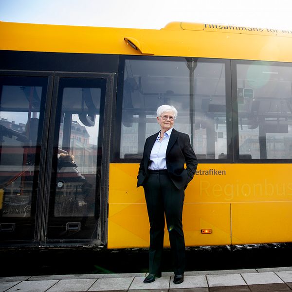 Carina Zachau (M) framför en gul buss i Skåne