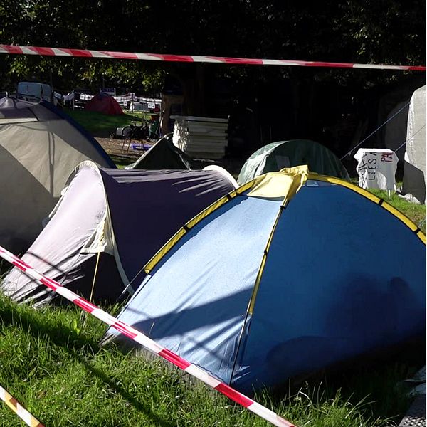En delad bild med två sektioner. Den vänstra sektionen visar flera tält som står på grön gräsmark, avskilt med röd-vita avspärrningsband. Den högra sektionen visar en person i en inomhusmiljö, klädd i en jacka och kavaj, som pratar in i en mikrofon.