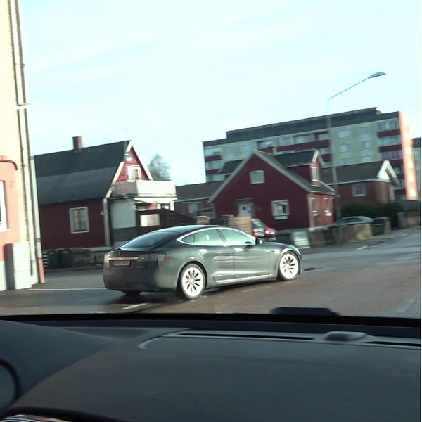 Bild delad i två sektioner: vänster sida visar en bil som kör genom ett bostadsområde med traditionella hus. Höger sida visar en reporter med SVT-mikrofon i ett utomhusområde framför en byggnad.