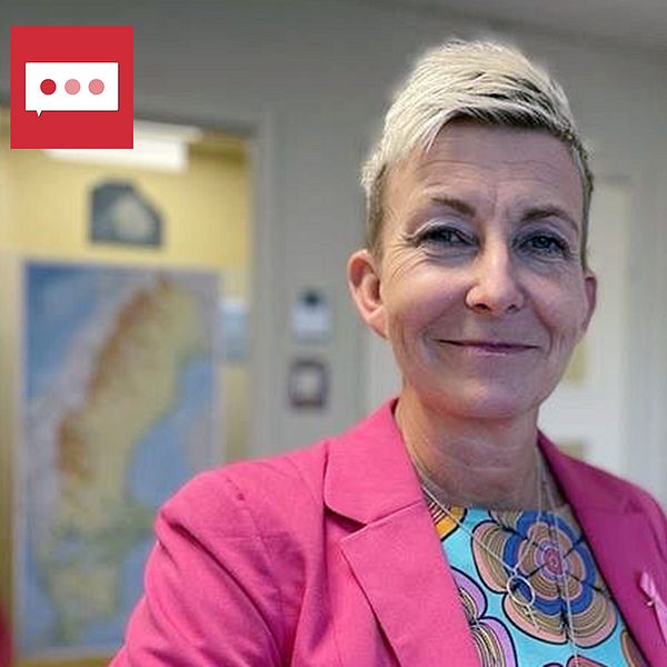 Marie Niljung, författare står iklädd en rosa kavaj och en färgglad mönstrad blus står i ett kontor. I bakgrunden syns en karta över Sverige samt böcker och konstverk på en hylla. Rummet har ljusa väggar och en vänlig atmosfär.