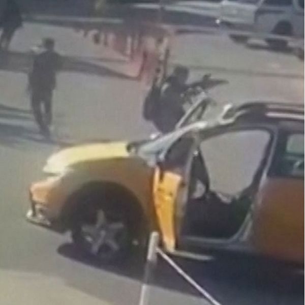 Bild som är uppdelad i två sektioner: Till vänster syns en öppen gul bil med en person som står bredvid med ett vapen, medan flera andra personer går i närheten. Till höger ses en explosion i bakgrunden, omgiven av parkerade bilar.