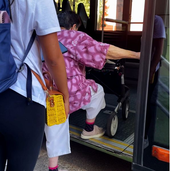 En äldre kvinna stiger på en buss och regionpolitiker.