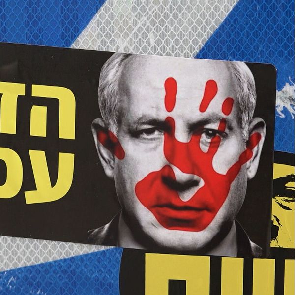 Affisch på Netanyahu med ett ”blodigt” handavtryck över ansiktet.