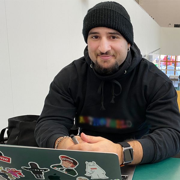 Suheib Lrubai sitter med sin dator i biblioteket på Mälardalens universitet där han är student.