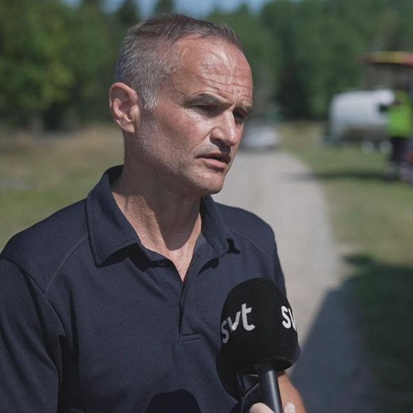 Man står framför räddningstjänstfordon