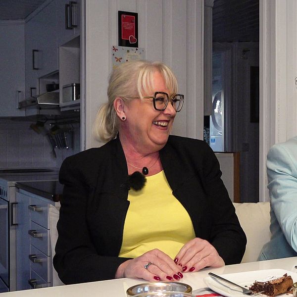 Edith och Udo Hitzke sitter vid sitt köksbord och kollar på varandra och skrattar