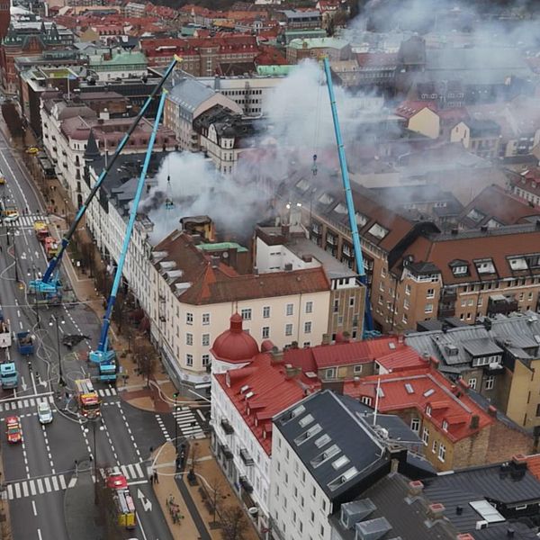 Rök stiger från en byggnad i centrala Helsingborg där räddningstjänst använder skyliftar för att bekämpa en brand på hotell. Den andra sektionen visar en person i en mörk jacka, som står nära en gata.