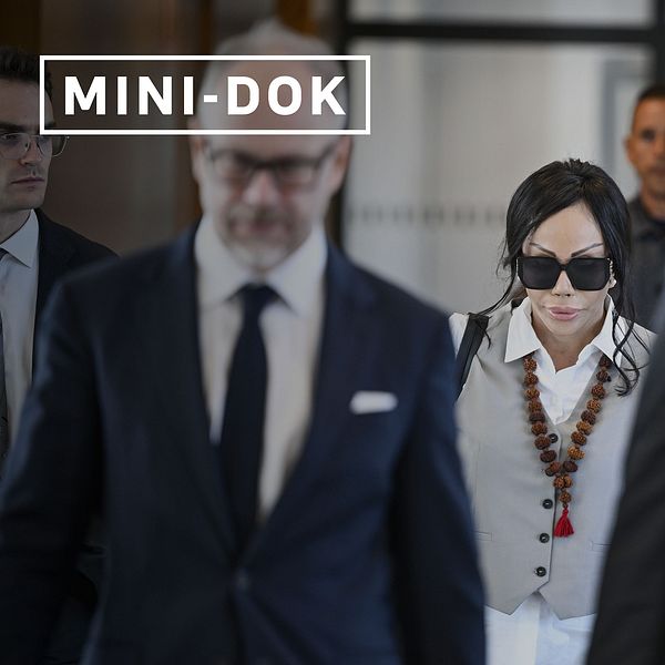 Flera personer i kostym och en kvinna med halsband och stora solglasögonen promenerar i tingsrätten.