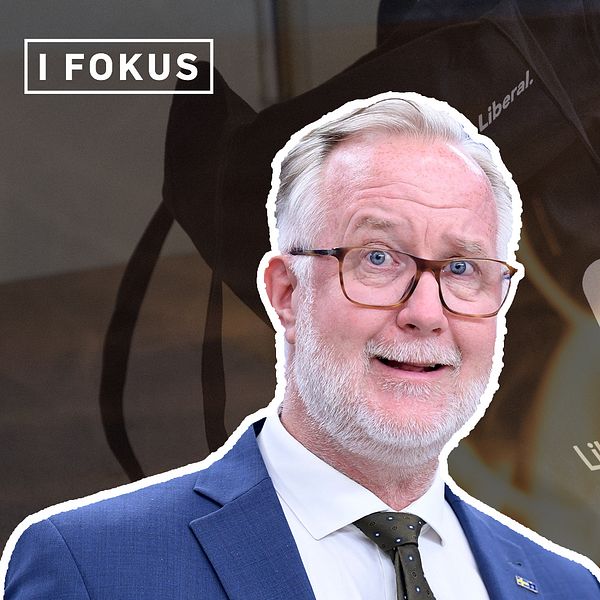Man i kostym framför Liberalernas logga och eldslågor, texten ”I FOKUS” uppe till vänster.