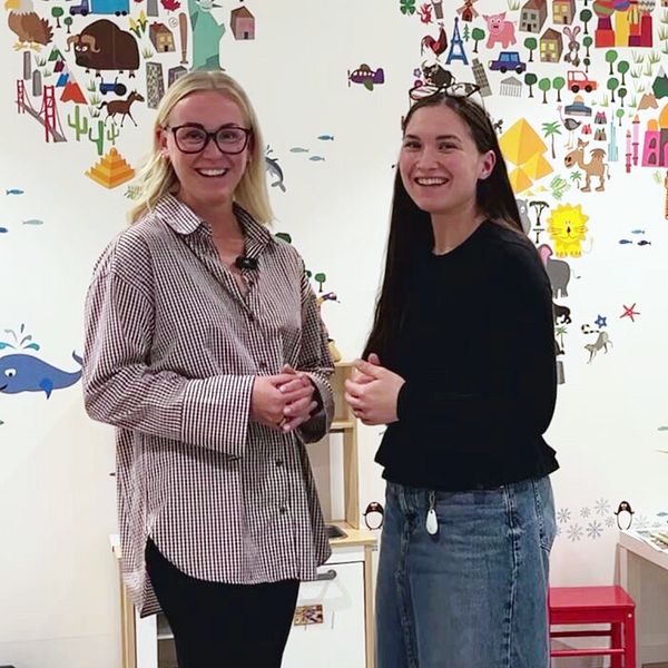 Julia Norrman och Nathalie Johansson Sundel framför en vägg med barnteckningar