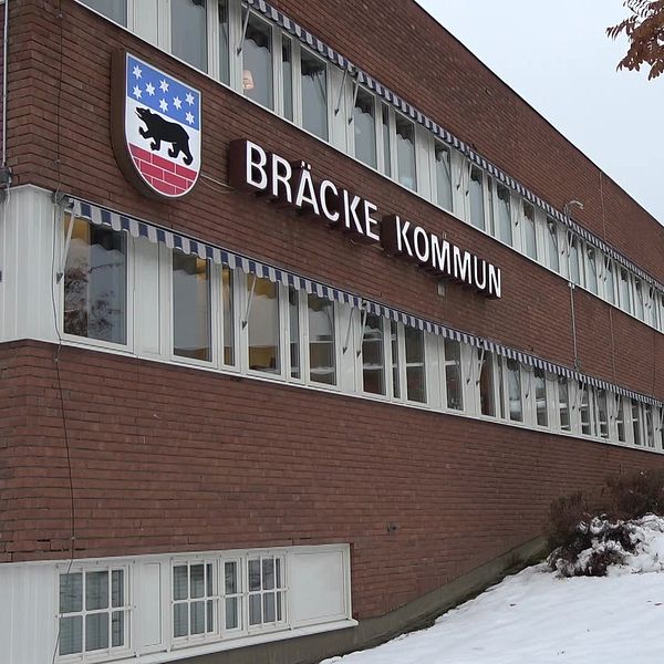 Byggnad med texten ”Bräcke kommun”, snö på marken och träd i förgrunden.