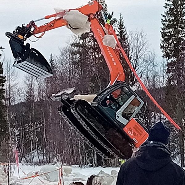 En grävmaskin lyfts upp ur en myr i Solberg i Örnsköldsviks kommun. Det sitter fast stora isblock på grävaren.