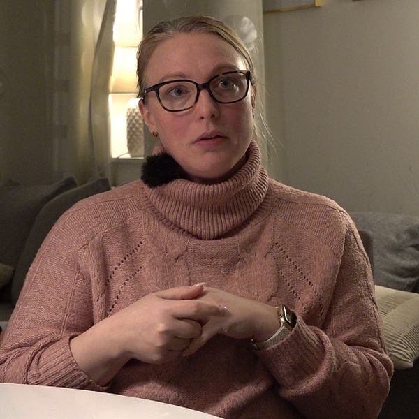 Josefine Rundquist ser upprörd ut och ihop händerna. Baksidan av reporterns huvud är till höger.