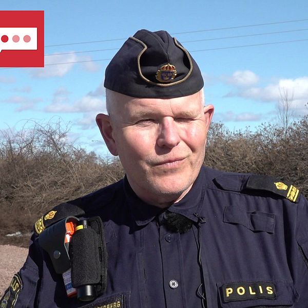 Polis som står och kisar in i solen.