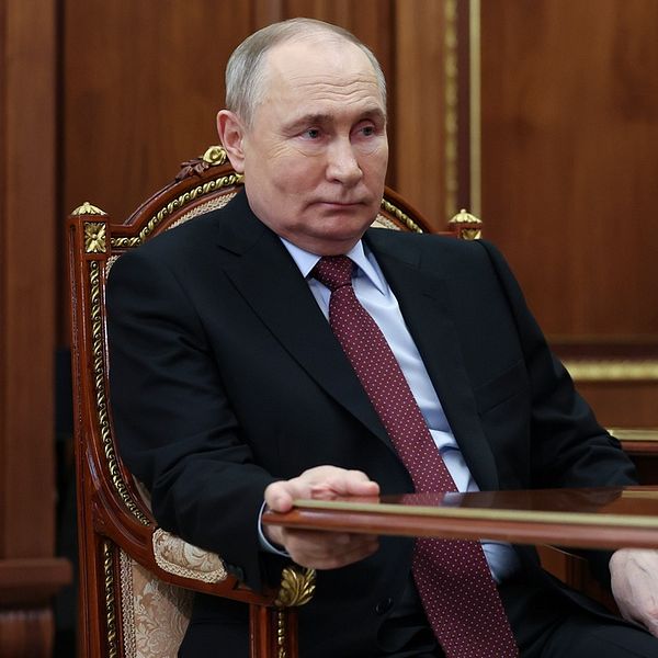 Rysslands president Vladimir Putin sitter på en gudbeklädd stol.