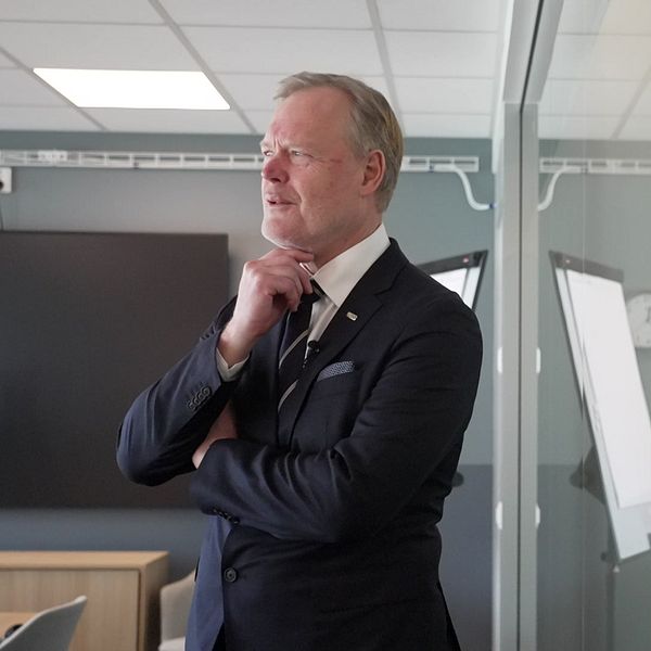 Person vid fönster i kontorsmiljö.