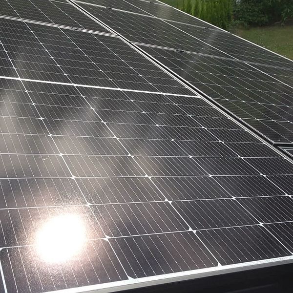 Solceller på tak och kvinna i porträttbild.