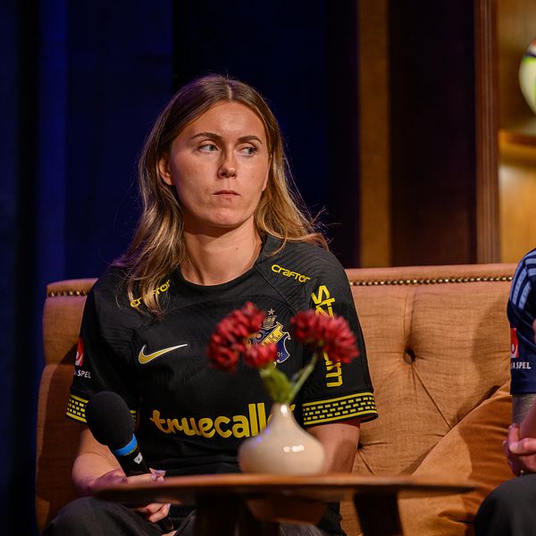 Två personer i AIK och Djurgården-tröjor sitter i en studio.