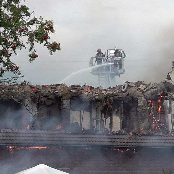 Brandmän på en stege försöker släcka moskébranden i Årby i Eskilstuna