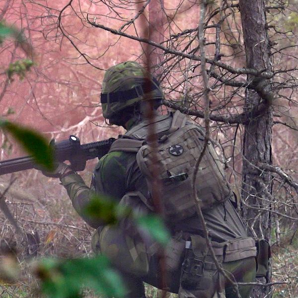 en soldat i uniform syns i skogen. Till höger i bild syns Dan Rasmussen.