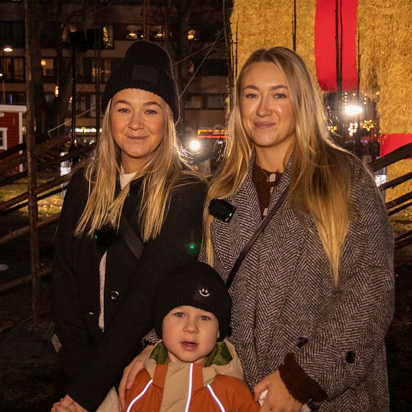 Till vänster syns tre personer som besöker invigningen av Gävlebocken 2024. Till höger syns själva bocken.