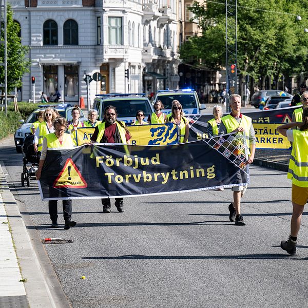 Människor protesterar på en gata med stora banderoller