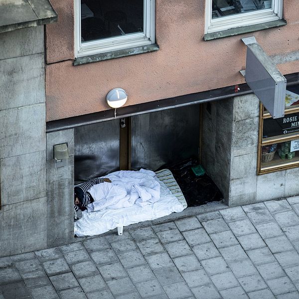 Hemlös person som sover ute på gatan.