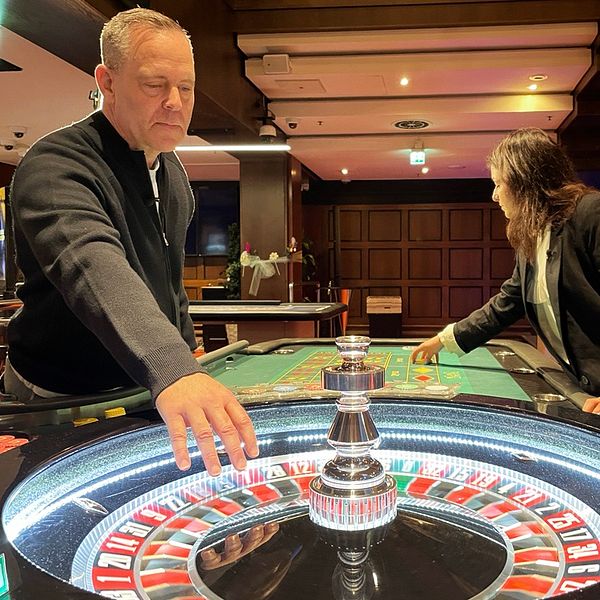 Två personer spelar vid ett roulettebord på ett kasino.