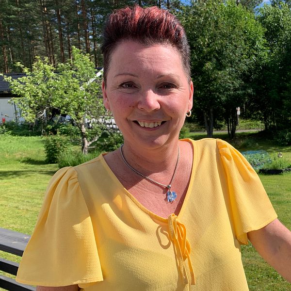Sångerskan Anki Strandberg står i sin trädgård