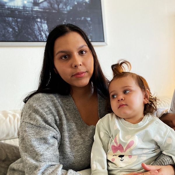 Föräldrar som sitter i soffa med sina barn.