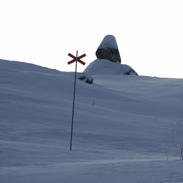 En skoterled i skymningsljus och en fjällräddare inomhus