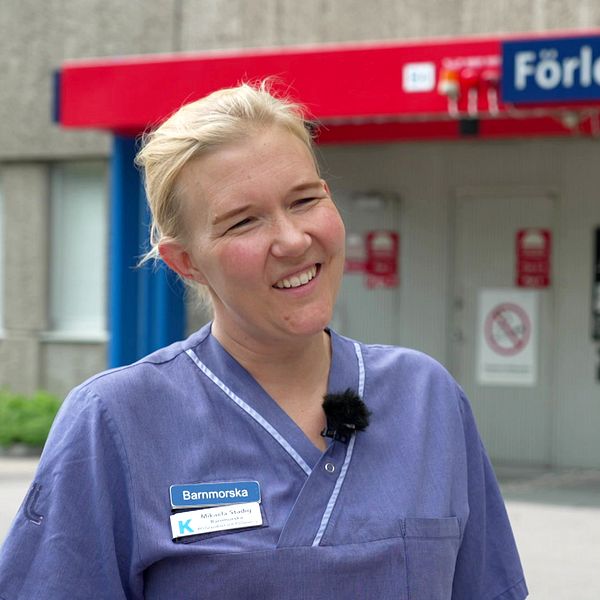 Portrttbild på barnmorskan Mikaela Stadig som är blond, har rosiga kinder och ett stort leende.