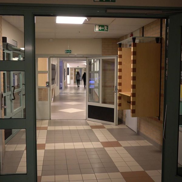 En korridor i en skola och en kvinna i medelåldern