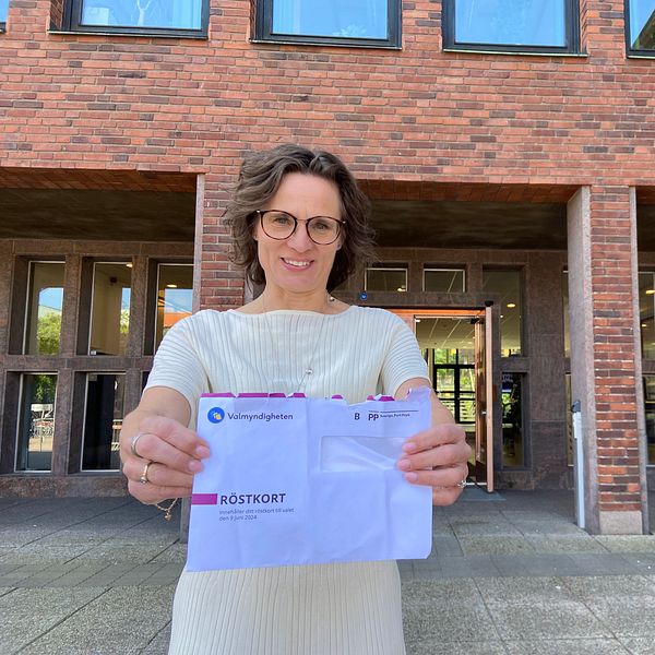 EU-ministern Jessika Roswall (M) förtidsröstade till EU-valet på rådhuset i Halmstad. Hon står framför rådhuset och håller upp sitt kuvert med röstkortet från valmyndigheten.