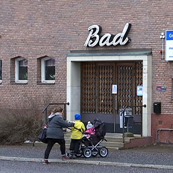 En kvinna skjuter en barnvagn framför sig, på väg in till badhuset i Grängesberg.