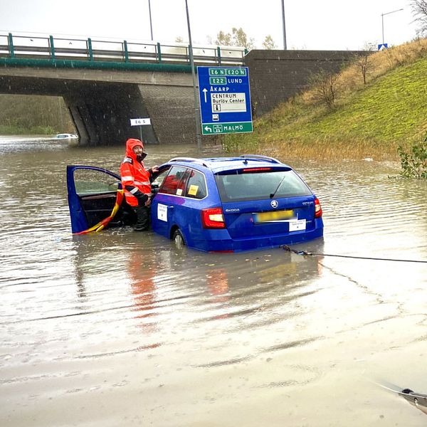 Två personer som bärgar en bil i Arlöv som har hamnat i vatten.