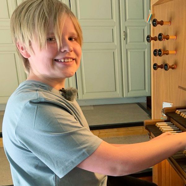 Pojke sitter vid orgel