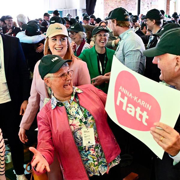 Människor i folkmassa. En person håller skylt med texten ”Jag älskar Hatt” på rosa hjärta.
