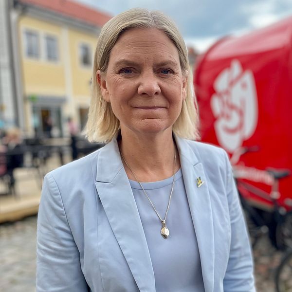 Magdalena Andersson framför röd vagn på gatan